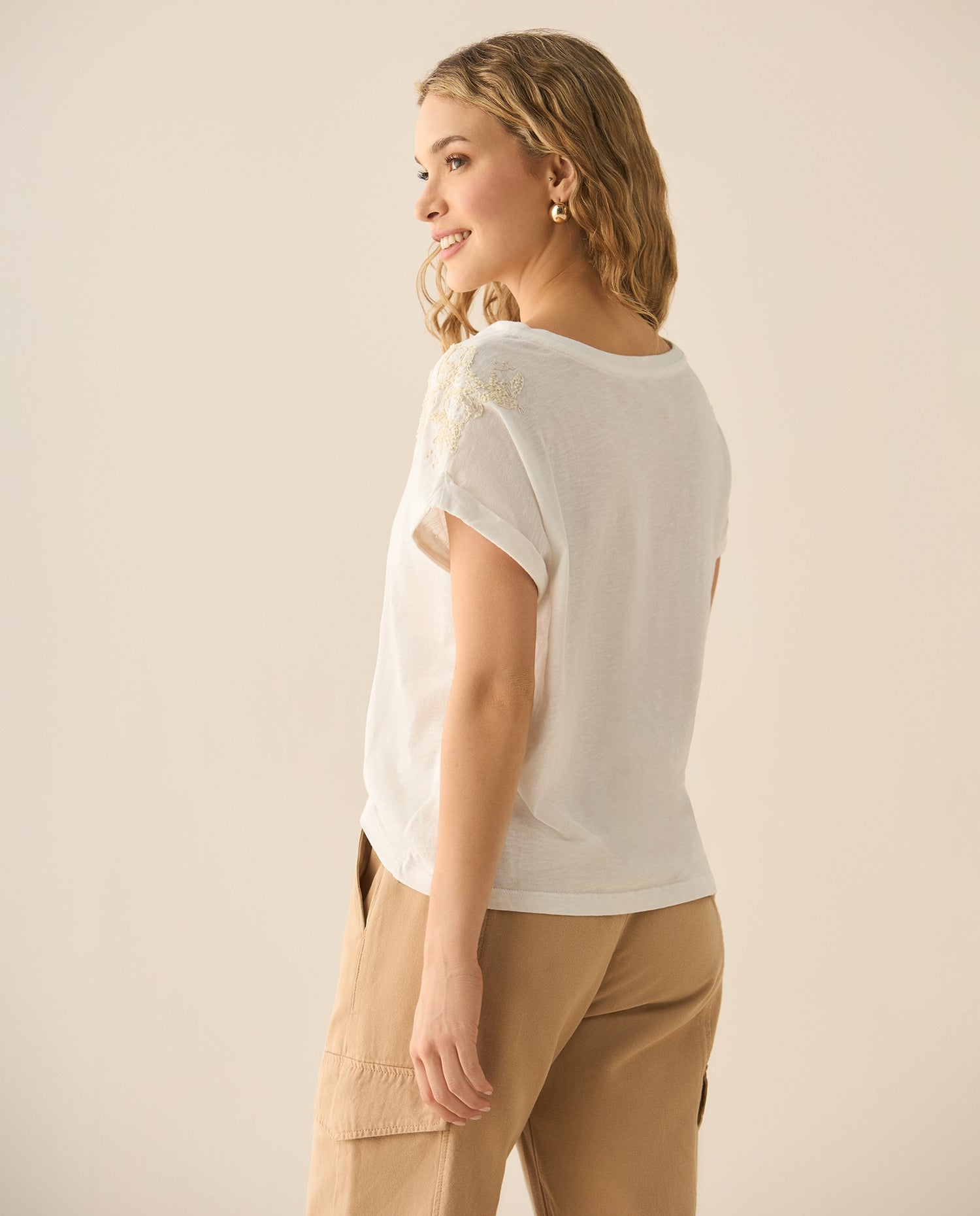 Camiseta tradicional con apliques bordados y de piedras en mangas para mujer. - Crudo